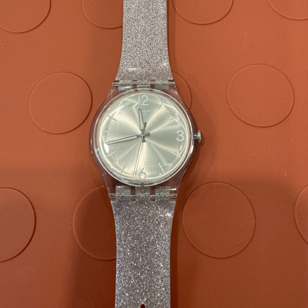 SWATCH watch - Shimmery silver band with iridescent watch face.